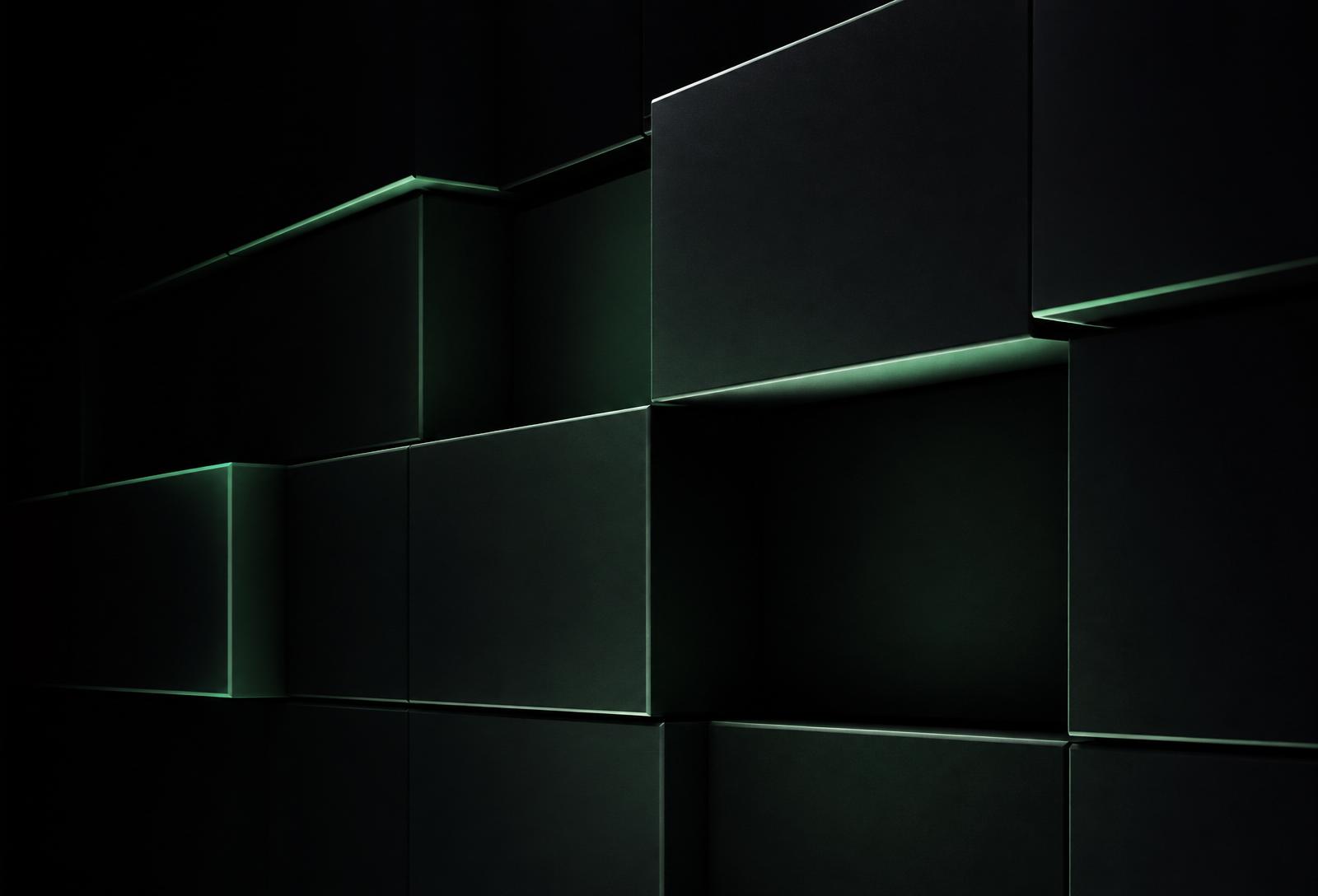 Volúmenes modulares oscuros con luz verde en los bordes, representación abstracta de un sistema modular